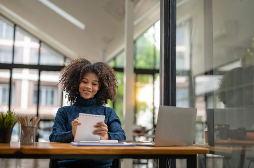 A woman smiles while sitting at a desk